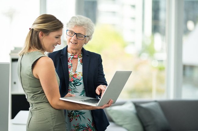 Two educators collaborating on a laptop